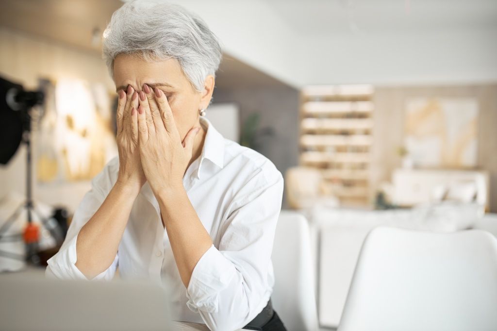 senior-sad-woman-with-gray-hair-working-laptop-rubbing-eyes-hiding-tears-full-restless-thoughts.jpg